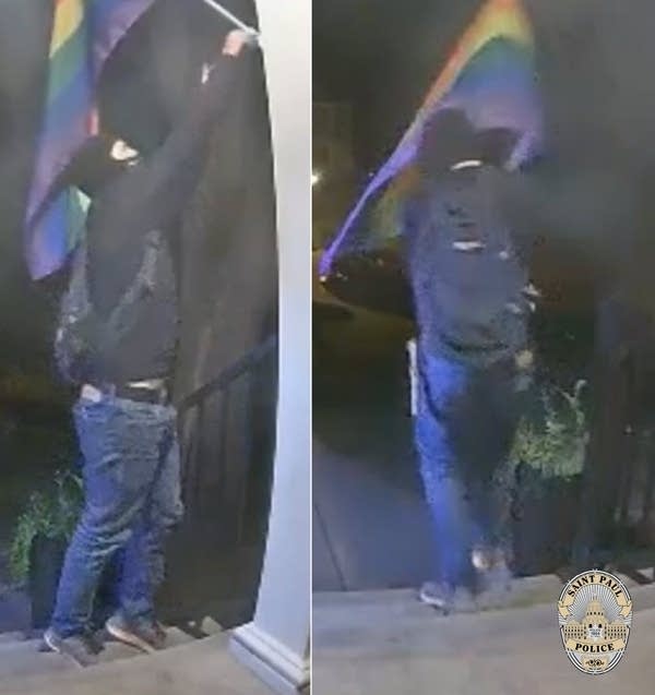 man wearing mask takes down flag