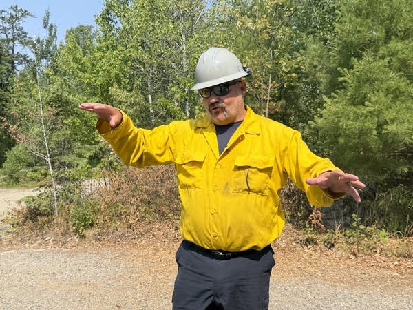 A person in a hard hat and yellow shirt 