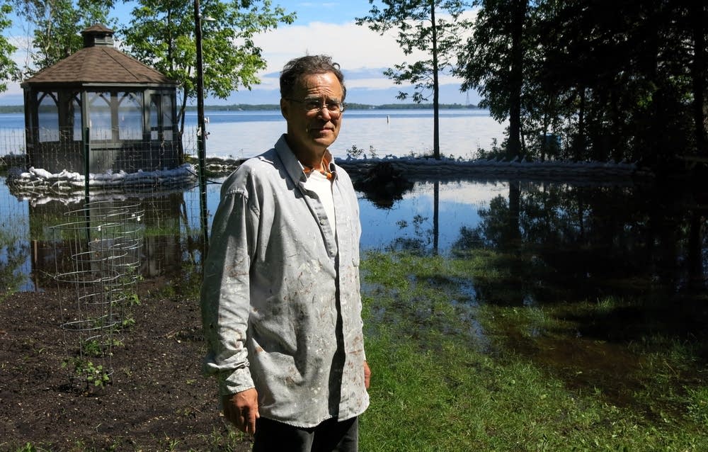 Fred Smith stands in his flooded Rainy Lake yard.
