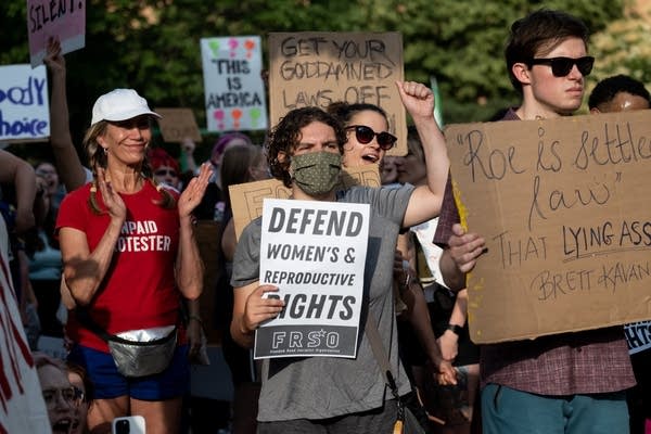 Protesters hold signs