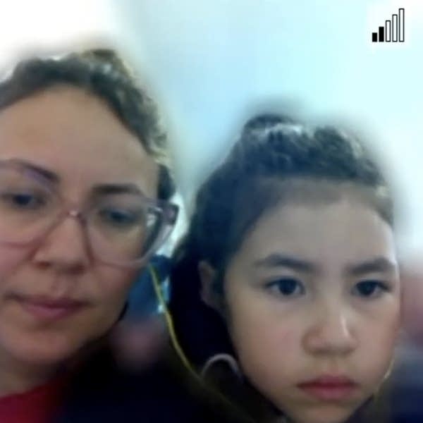 little girl and parent look at camera