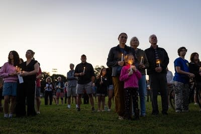 People stand during a vigil