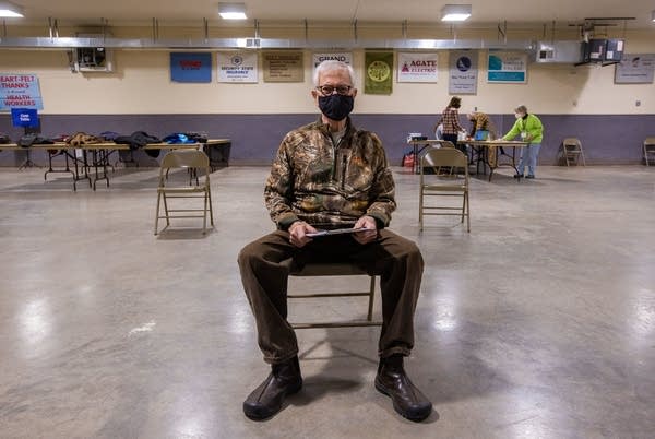 A man sits in a chair waiting. 