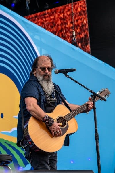 steve earle performing on stage with an acoustic guitar