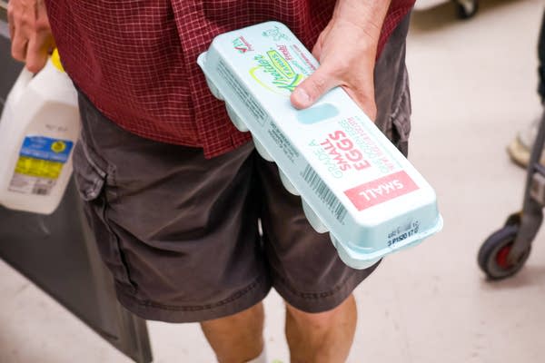 A person holds a carton of eggs.