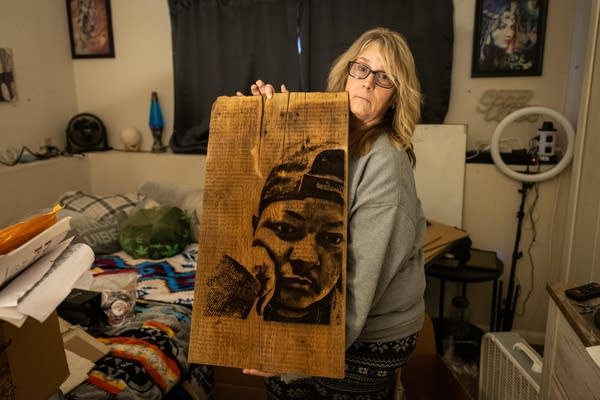 A woman holds a piece of art