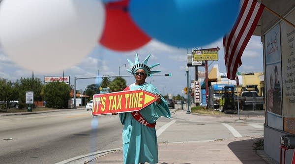 Armando La Rosa directs people to the Liberty Tax Service office as the deadline to file taxes looms on April 15, 2016 in Miami, Florida. 