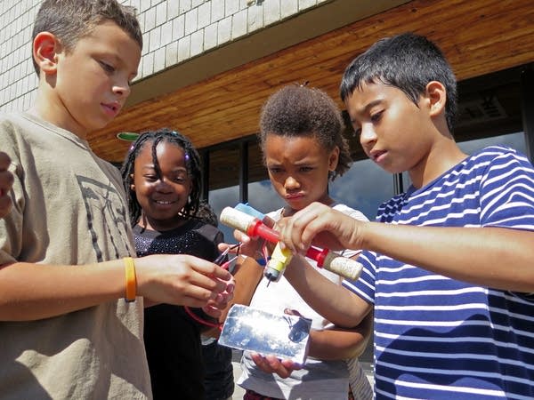 Campers test a solar-powered boat motor.