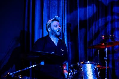 A musician plays drums in a music venue