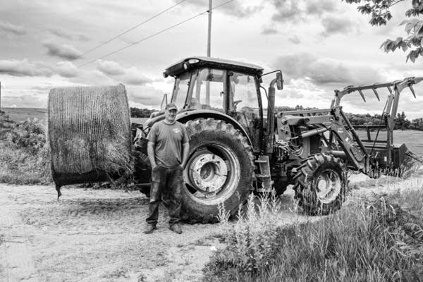 a man stands near a farm tractor