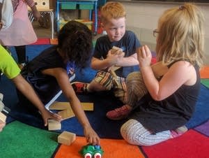 Preschool students at Gideon Pond Elementary school clean up their toys.
