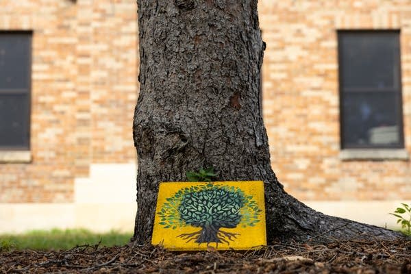 A small hand-painted paver sits on the ground