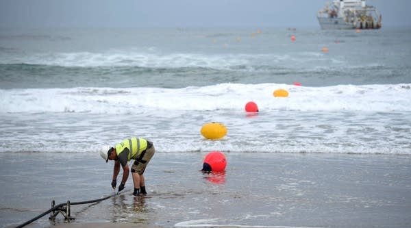 An operator works during the mooring of an undersea fiber optic cable at Arrietara beach near the Spanish Basque village of Sopelana in June.