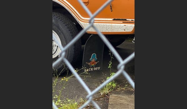 Photo taken thru fence of truck mud flaps w/ Yosemite Sam