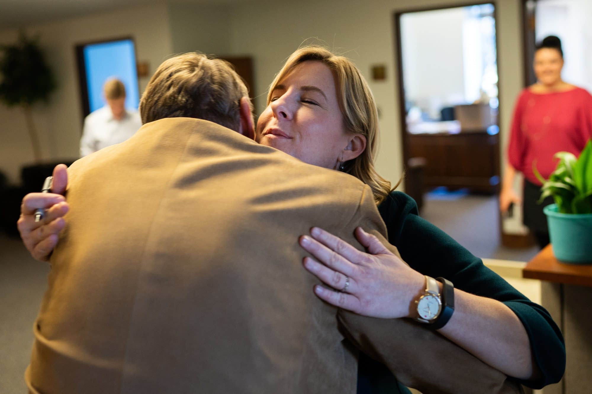 Rep. Melissa Hortman (DFL) hugs Rep. John Persell (DFL).