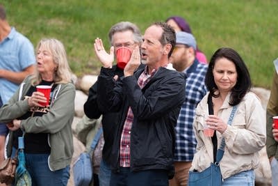 Music fans applaud and cheer during a performance at an outdoor venue