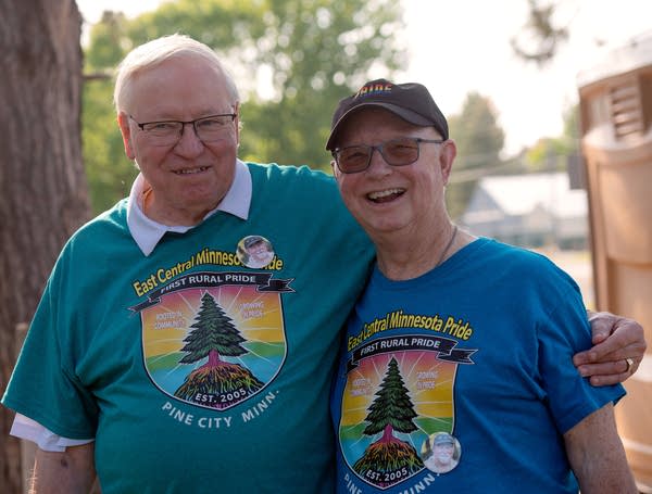 Two people in glasses smiling and posing for pic