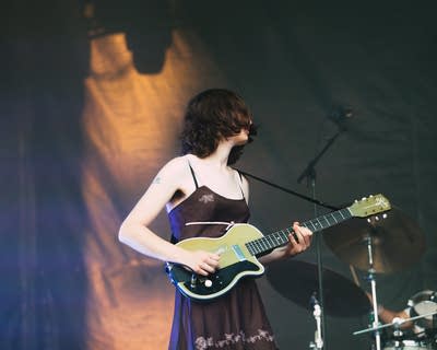 Emily Green of the band geese playing guitar on stage