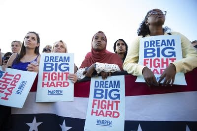 A group of women lean hold signs that say "Dream Big, Fight Hard."