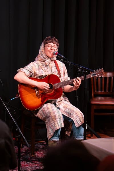 Lambchop performs seated on a stage.