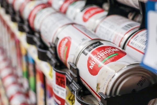 Close-up of cans of soup on a store shelf.