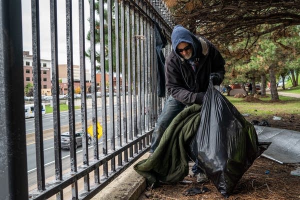 Marty Thomas packs blankets he hung to dry into a garbage bag.