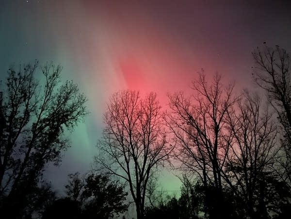 The northern lights fill the sky in shades of brilliant green and red