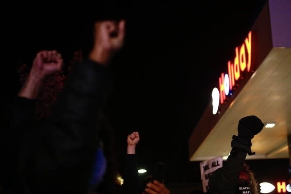 Fists in the air outside a gas station. 