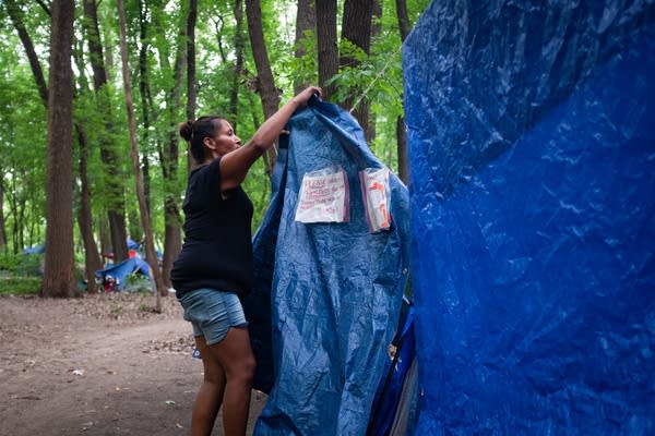 A woman hangs up a tarp