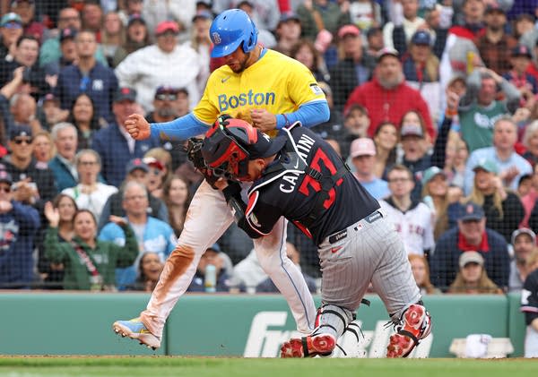 A runner collides with a catcher at home plate.