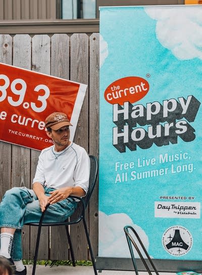 DEHD's Jason Balla next to Happy Hour banner