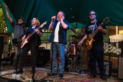 a rock band performing on an outdoor stage