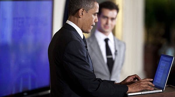 U.S. President Barack Obama posts a tweet during an online Twitter Town Hall meeting from the East Room of the White House July 6, 2011 in Washington, D.C.