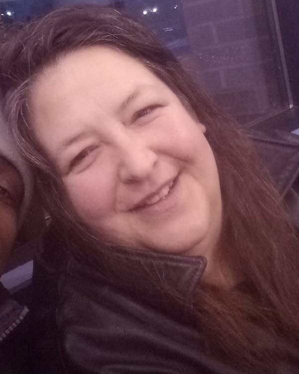 A woman wears a black leather jacket.