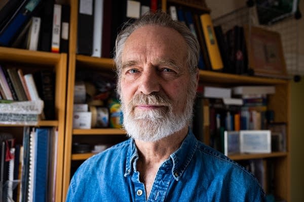 A man poses in a home office