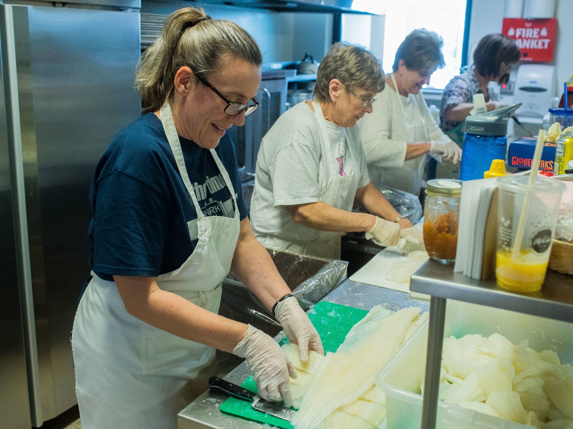 Catherine Anderson and Char Juntunen cut lutefisk and puts it into bins.