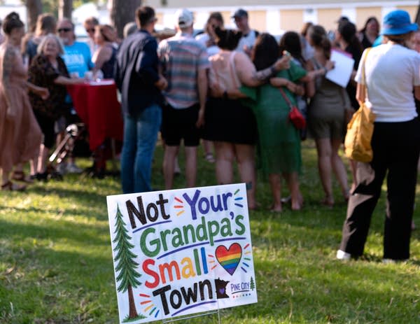 Sign standing outside with people in the background