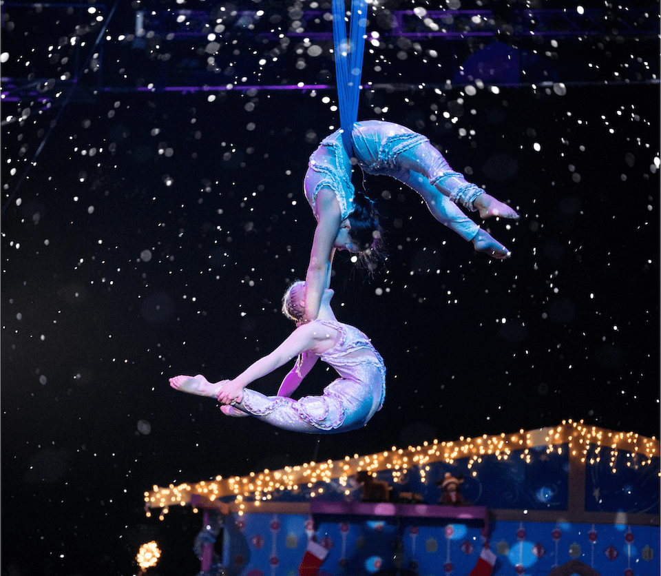 Two performers swing from the ceiling.