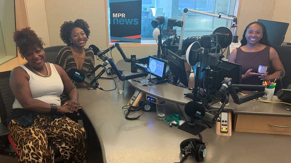 three women smiling in a broadcast studio