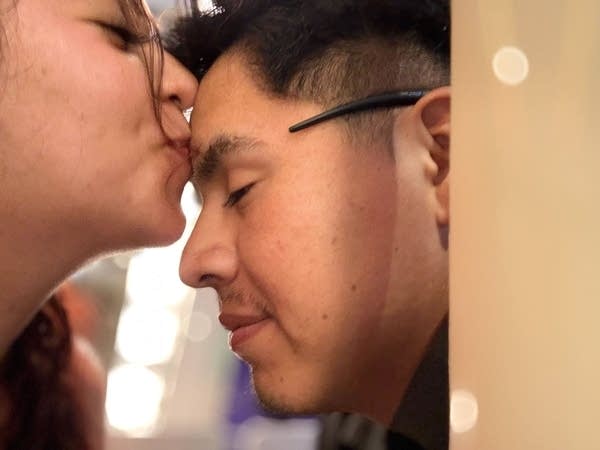 woman kissing man on forehead
