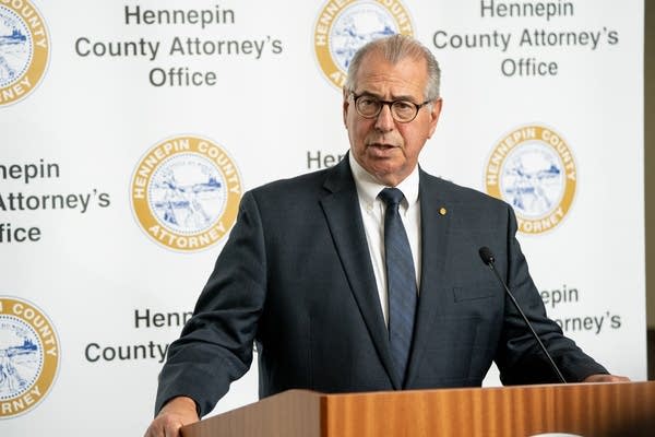 Mike Freeman stands at a podium with a microphone. 