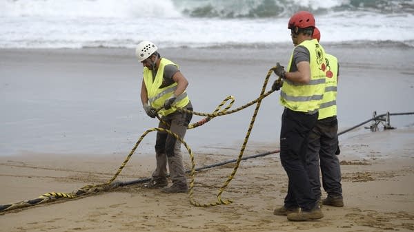 Governments can be doing more to make sure undersea cables stay intact, said UT Austin's Kevin Frazier. Above, operators handle an undersea fiber optic cable in Spain.