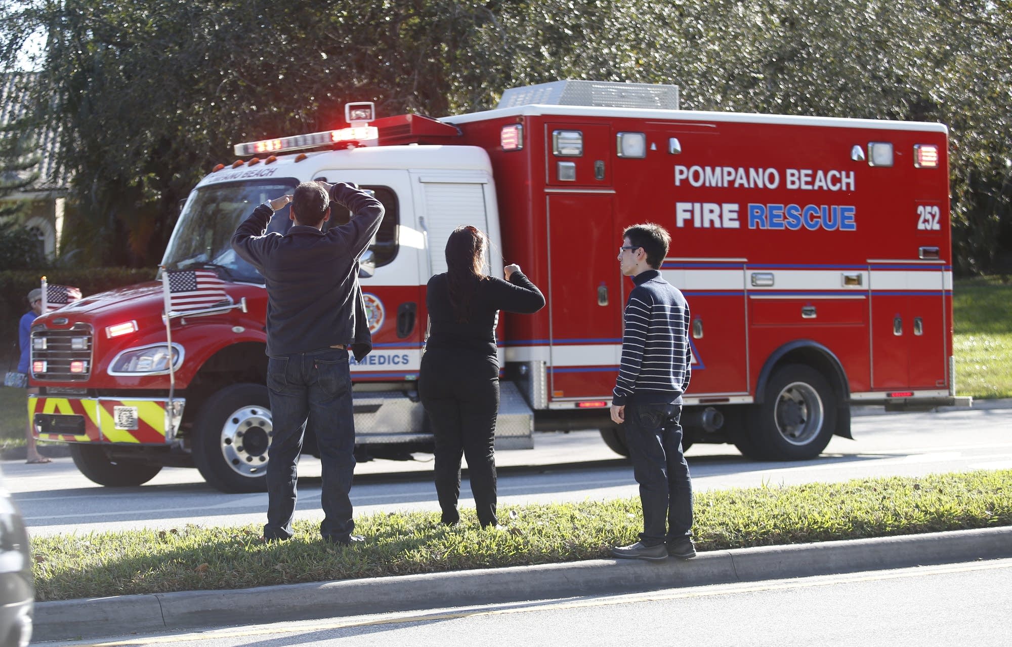 Anxious family members watch a rescue vehicle pass by.