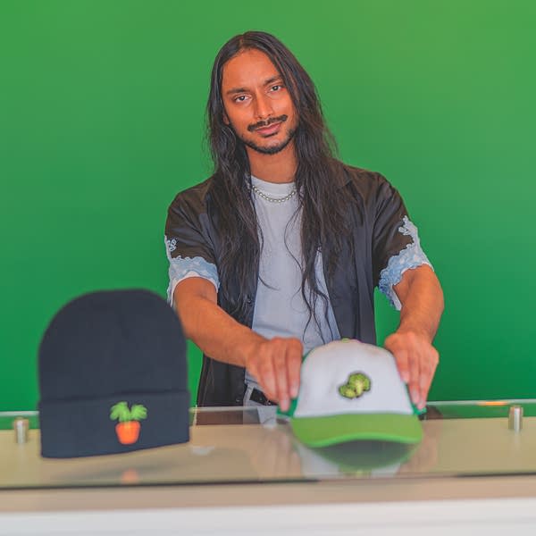 man poses with hats