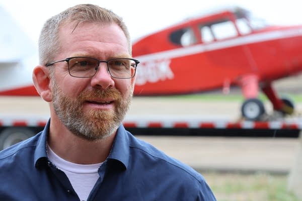A man stands nearby an airplane.