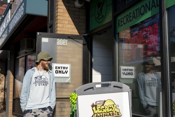 A man stands in front of a storefront