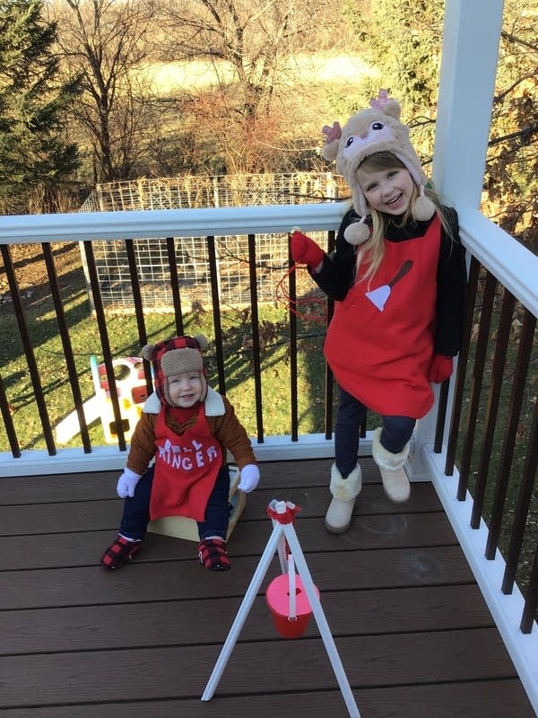 Two children wearing red aprons. 