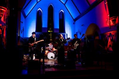 A band performing onstage in a church