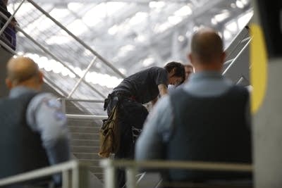 A woman climbs down from the stadium grid.