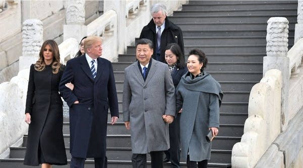 President Donald Trump, walking with first lady Melania Trump, looks at China's President Xi Jinping and his wife, Peng Liyuan, as they tour the Forbidden City in Beijing today.
